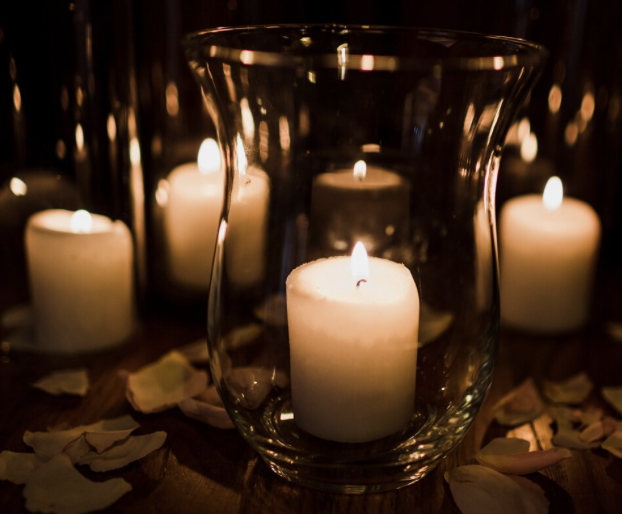 Altar con velas, flores y fotografía de David Cohen, abogado mexicano asesinado, en una ceremonia de homenaje.