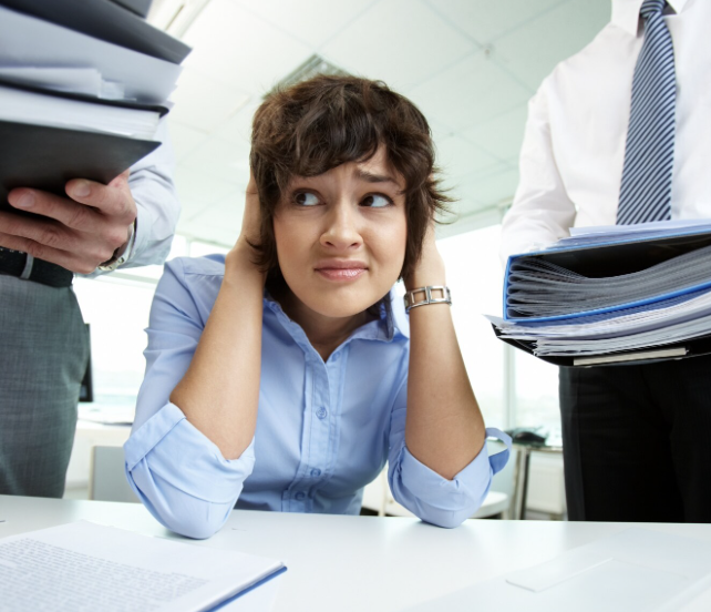 Mesa de trabajo con documentos legales, computadora, teléfono y pruebas de acoso laboral.